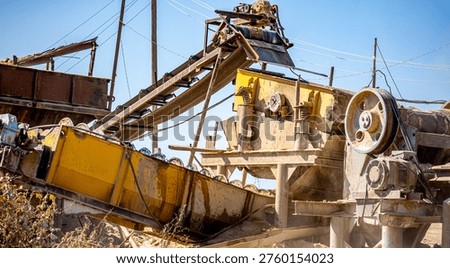 Vibrating screen stone crusher in operation. Crushing stones in a quarry for processing minerals, cement, limestone. Heavy and mobile equipment in a quarry for processing stone into building material.