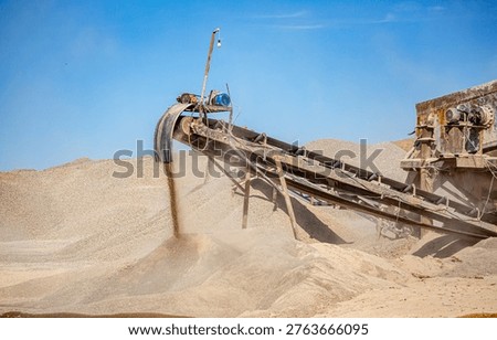 Vibrating screen stone crusher in operation. Crushing stones in a quarry for processing minerals, cement, limestone. Heavy and mobile equipment in a quarry for processing stone into building material.