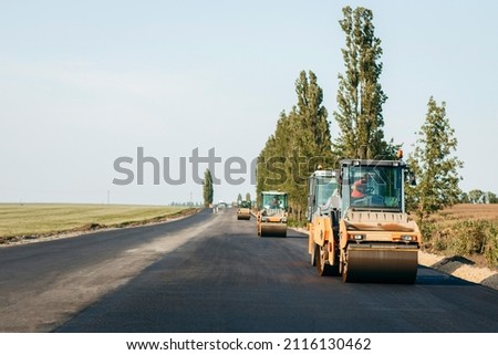 Vibratory asphalt roller compactor compacting new asphalt pavement. Road service repairs the highway