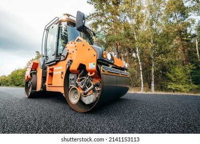 Vibratory asphalt rollers compactor compacting new asphalt pavement. Road service build a new highway