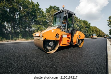 Vibratory asphalt rollers compactor compacting new asphalt pavement. Road service build a new highway	
