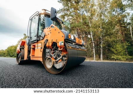Vibratory asphalt rollers compactor compacting new asphalt pavement. Road service build a new highway