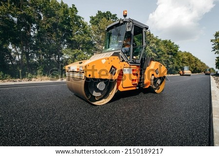 Vibratory asphalt rollers compactor compacting new asphalt pavement. Road service build a new highway	
