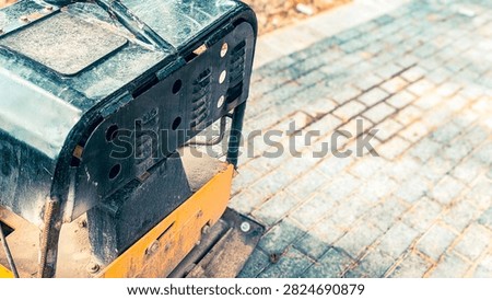 vibratory plate compactor machine on paved walkway