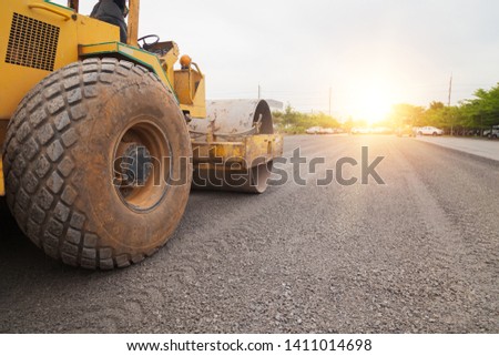 Vibratory roller compactor working on construction site.