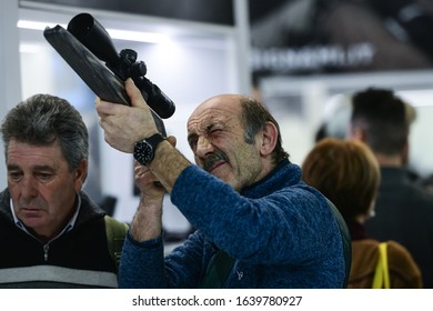 Vicenza, Italy - February 8, 2020: A visitor inspects a weapon on display at Hit Show 2020, trade fair show  dedicated to hunting, target sports and outdoor in Vicenza, Italy