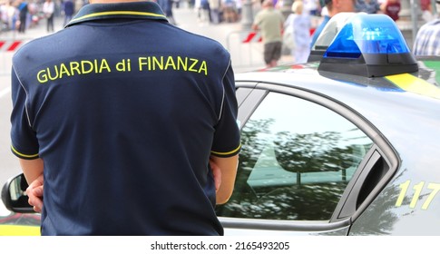 Vicenza, VI, Italy - June 2, 2022: Policeman with uniform and text GUARDIA DI FINANZA that means Financial Police in italian language and the car with sirens