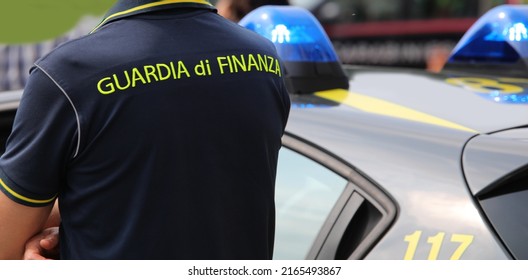 Vicenza, VI, Italy - June 2, 2022: Policeman with uniform and text GUARDIA DI FINANZA that means Financial Police in italian language and the car with sirens at checkpoint