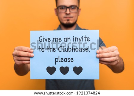 VICHUGA, RUSSIA - FEBRUARY 20, 2021: man with a banner in need of an invitation to the trending Clubhouse app on a yellow background