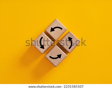Vicious circle in business or life concept. Routine, comfort zone and inertia in everyday procedures and processes. Arrows forming a circle on wooden cubes.
