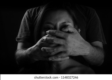 Victim of domestic violence, Human trafficking concept, End to violence against women,Scared woman with man's hand covering her mouth,