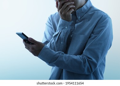 Victim Of Internet Fraud And Bullying. Man Seeing Smartphone With Shocked Look.
