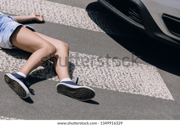 Victim of a traffic accident on pedestrian crossing\
next to a car