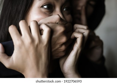Victim young woman get shock and terrified when bad guy use hand close her mouth for stop scream Dangerous man want to abducted her for ransom Kidnap asian girl is one of victim of human trafficking