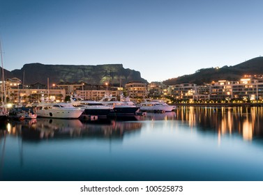 Victoria and Alfred Waterfront as the hot summers sun sets behind Table Mountain and the night lights start to shine - Shutterstock ID 100525873