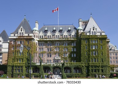 VICTORIA - AUGUST 2: The Canadian Flag flies on top of the Fairmont Empress Hotel with Tourists passing by on August 2, 2005 in Victoria, Canada. This luxury hotel was opened 1908.