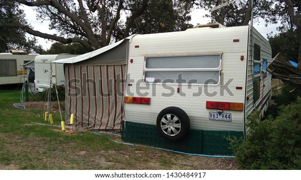 VICTORIA, AUSTRALIA - MAR 29, 2016: Retro\
vintage campervan park at the historic city town beach village\
during cloudy day, Victoria,\
Australia.