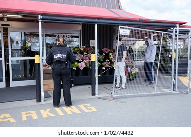 Victoria, BC / Canada - Apr 11 2020: Security Guard Outside Grocery Store Country Grocer, Enforcing Social Distancing And Controlling Access