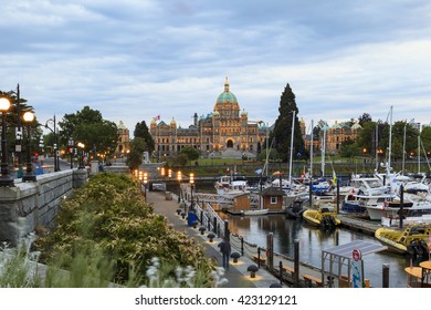 VICTORIA, BC, CANADA - MAY 17 2016: Night view of the Inner Harbor Downtown. Tourists strolling the causeway. This waterfront is the location of many tourist attractions and recreational activities.