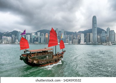 Victoria Habour, Hong Kong - March 21 2019: Iconic Traditional Red Junk Boat Cruising Around Hong Kong Skyline.