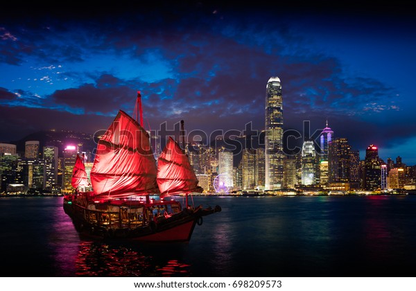 Victoria Harbour Hong Kong night view with\
junk ship on\
foreground