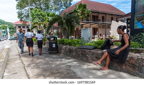 Victoria, Seychelles - January 7, 2020: Central Street Of Victoria City With Local Creole People Walking And Sitting.