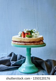 Victoria sponge cake with strawberrie jam standing on cake holder