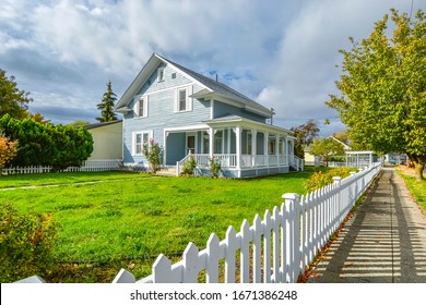 A Victorian cottage with a white picket fence and covered front porch and deck in the Spokane, Washington area of the Inland Northwest, USA.