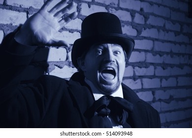 Victorian style frightened man screaming in a dark street