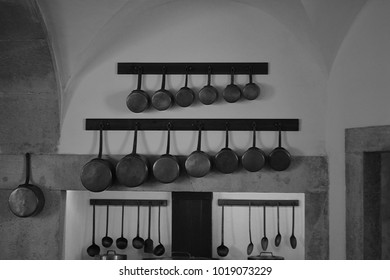 Victorian Style Kitchen Interior With Rustic Stone And Copper Pans Hanging From Wooden Shelves Black And White Interior Design Idea With Vintage Old Classic Feel