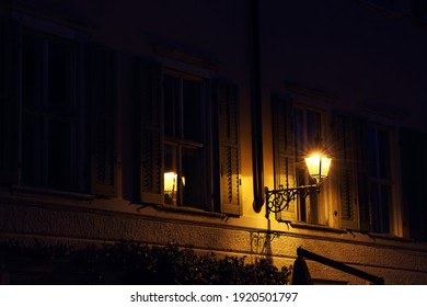 Victorian Vintage Antique Street Warm Yellow Light Lantern At The Night On The Wall Of Old Historic Italian Facade With Classic Italian Shutters On The Windows