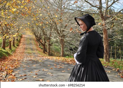 Victorian Woman On Autumn Road With Bonnet Back View 