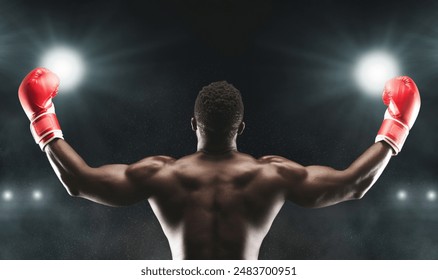 A victorious boxer raises his arms in triumph after a successful match, showcasing his muscular physique and determination. - Powered by Shutterstock