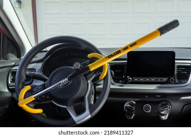 Victorville, CA, USA – August 11, 2022: The Club Twin Hook Steering Wheel Security Lock In Yellow Attached To A Kia Rio Car. 