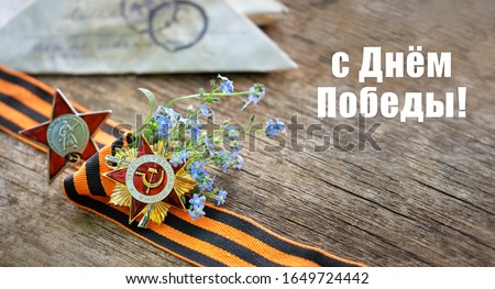 Victory Day holiday - russian text. old Soviet military order of Second World war, Order of Red Star, George Ribbon close up on wooden background. traditional symbol of Victory Day 1945. greeting card