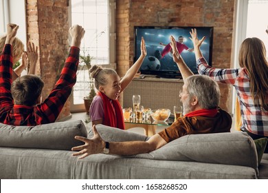 Victory. Excited, happy family watching soccer, football match, championship on the couch at home. Fans emotional cheering for favourite national team. Daughter, dad and grandpa. Sport, TV, having fun - Powered by Shutterstock