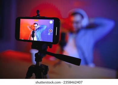 A video blogger records content in his studio. The backstage photo was taken from behind one of the participants in the shooting, at the beginning of the shooting when the blogger is preparing - Shutterstock ID 2358462407