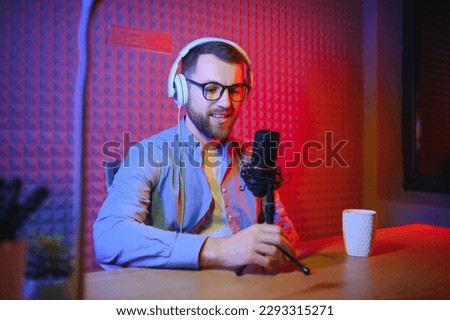 A video blogger records content in his studio. The host of the video blog is a young man who is very enthusiastic about telling his subscribers a story