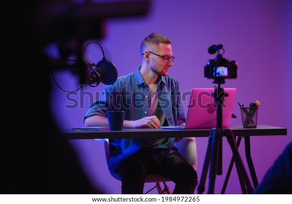A video blogger records content in his studio. The
backstage photo was taken from behind one of the participants in
the shooting, at the beginning of the shooting when the blogger is
preparing for the