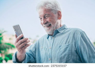 Video call concept. Handsome smiling bearded senior man talking on mobile phone using phone webcam to communicate in video chat - Powered by Shutterstock