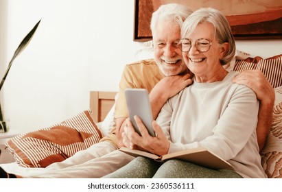 Video call concept. Portrait of happy handsome senior couple together in bed using phone webcam for video chat - Powered by Shutterstock