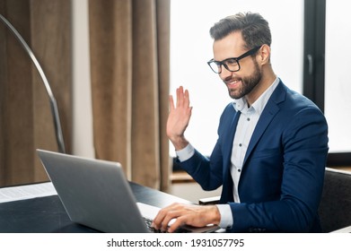 Video Call Concept, Young Good-looking Man Wearing Suit And Glasses Is Using A Laptop For Video Connection With Family, Remote Meeting, Say Hi, Looking At The Webcam, Glad To See, In Stylish Office