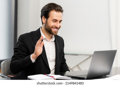 Video Call Concept, Young Good-looking Man Wearing Suit And Glasses Is Using A Laptop For Video Connection With Family, Remote Meeting, Say Hi, Looking At The Webcam, Glad To See, In Stylish Office