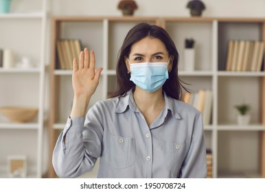 Video Call Or Conference, Covid19 Pandemic, Work On Lockdown. Young Caucasian Woman Remote Employee In Face Mask Wave Hand Hello To Camera Show Gesture Greeting Business Partner. Headshot Portrait
