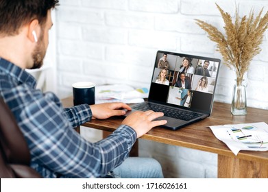 Video call. Online business meeting in video conference in the zoom app. A young attractive guy communicates with his colleagues on a video call using a laptop. Distant work at home - Shutterstock ID 1716026161