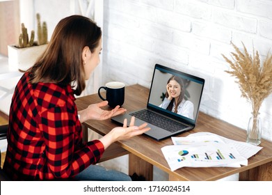 Video call. Two young attractive girls  communicate via video communication in zoom app using a laptop. Online meeting with friend