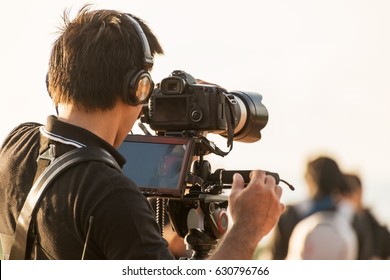 Video camera man operator working with professional equipment,filming recording - Shutterstock ID 630796766