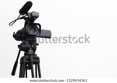 The video camera with the tripod isolated on white background.
