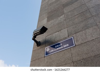 Video Cctv Camera And Blue Nameplate On Building Exterior And Clear Sky. Security Electronic Device And Urban House Architecture. Monitoring Surveillance Equipment Horizontal Photography