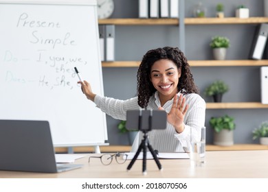 Video conference e-learning with teacher in room at home. Online education, social distancing, protect from COVID-19 viruses. Happy african american lady point at board, gesturing, look at webcam - Shutterstock ID 2018070506